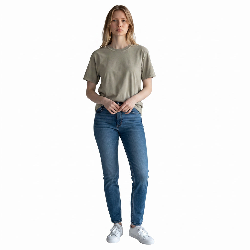 A woman wearing a PAPPAREL heavyweight vintage crewneck t-shirt in sage green with blue jeans and white sneakers.